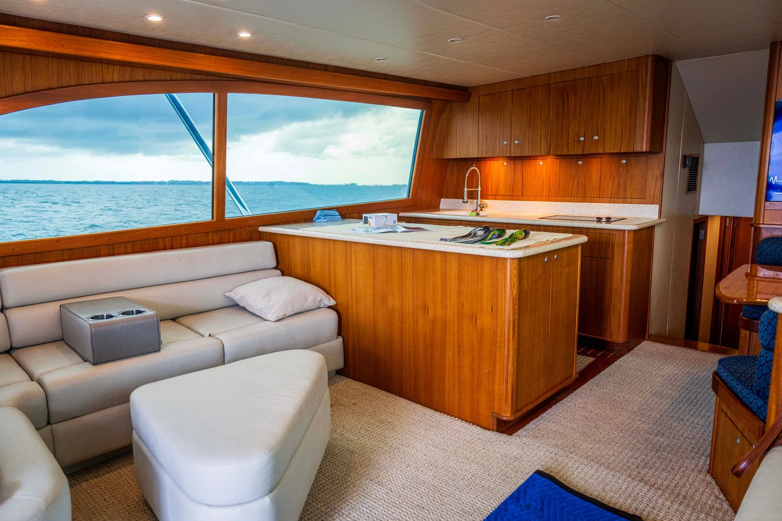 Carpeted yacht interior with wood cabinetry and sea views