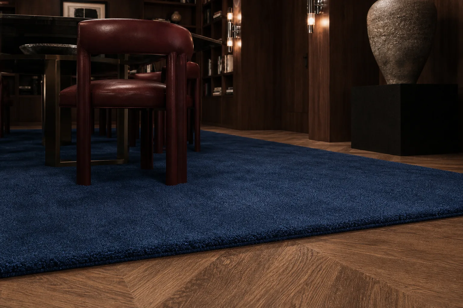 A Prussian blue MAJLIS rug detail under dining furniture in a wood-paneled room.